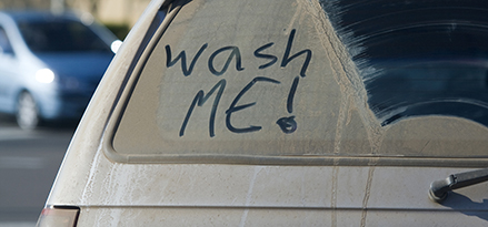 “Wasch-mich” , geschrieben auf einem schmutzigen Autofenster
